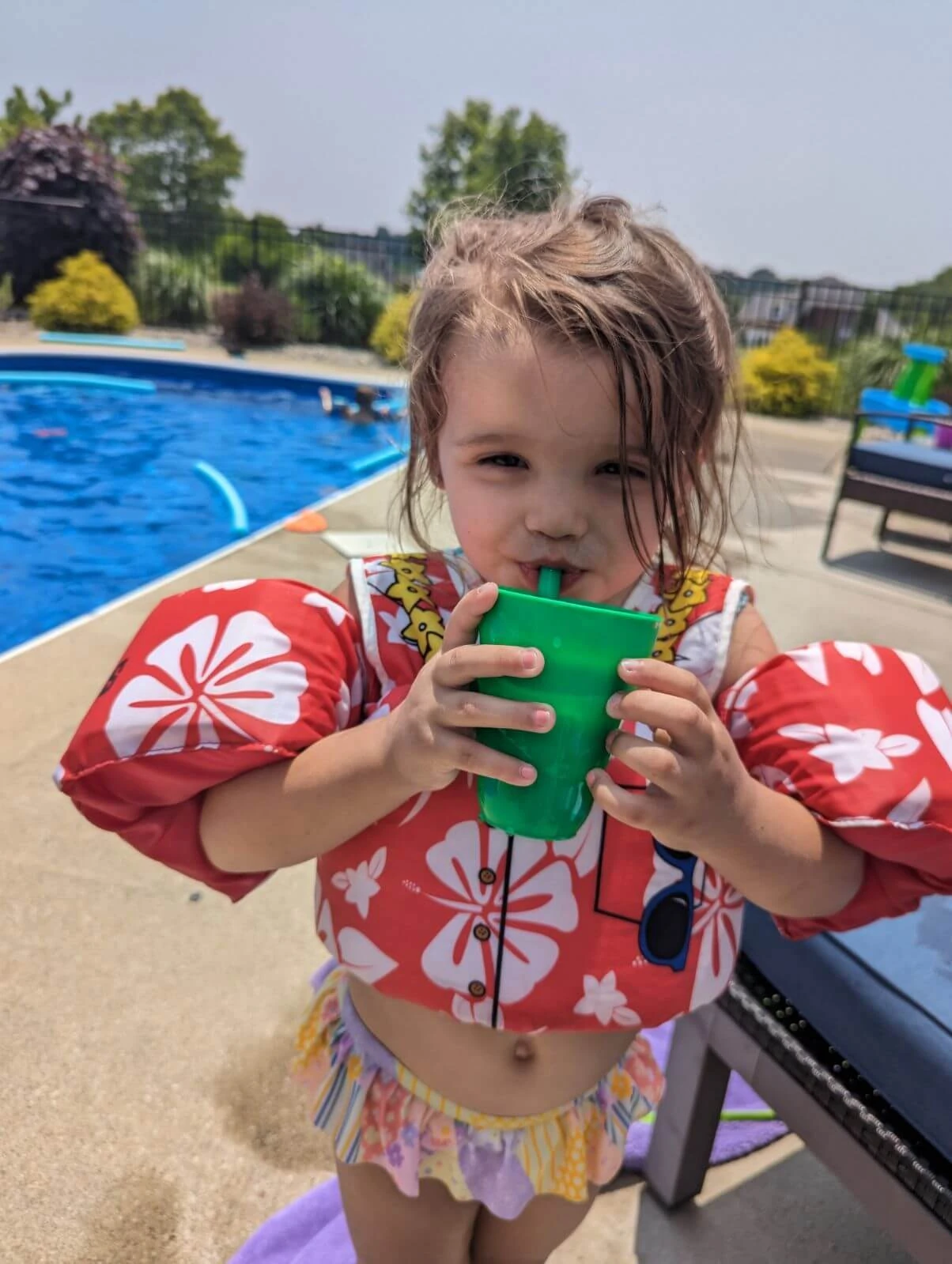 Child at pool party drinking tea